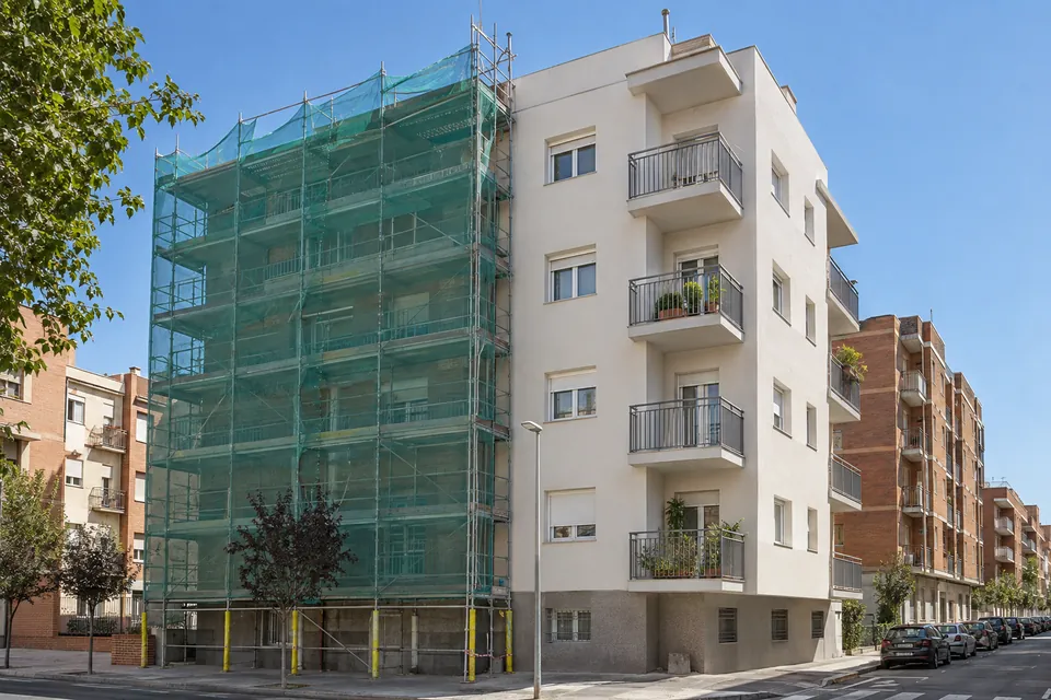 Bloque de pisos de los años 70 con andamio durante una rehabilitación energética de la fachada