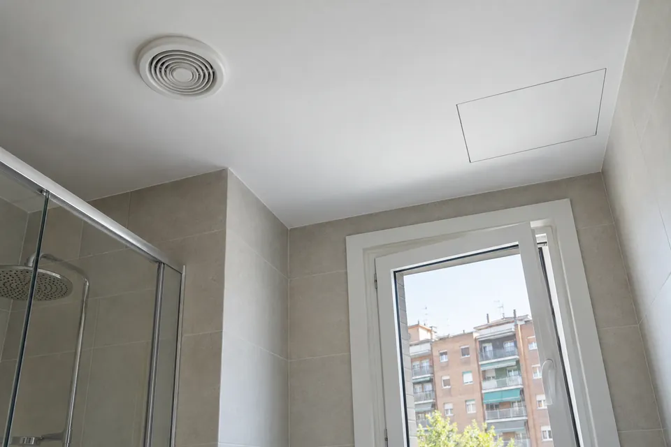 Techo de baño reformado con rejilla de ventilación y registro en el falso techo